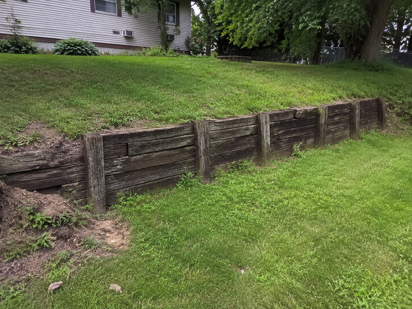Generated example of an aging timber retaining wall before replacement