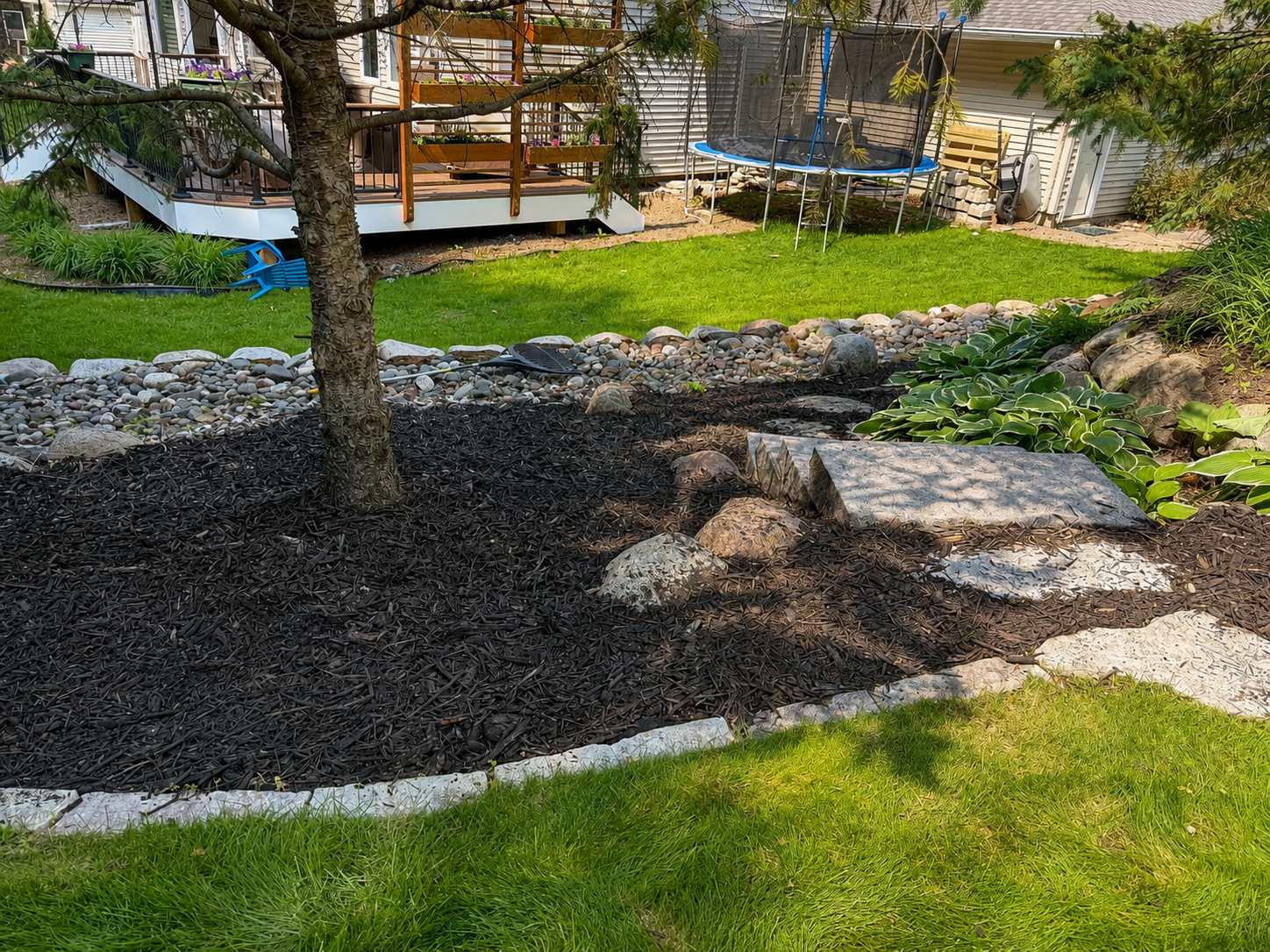 Landscaped backyard with stone steps and mulch